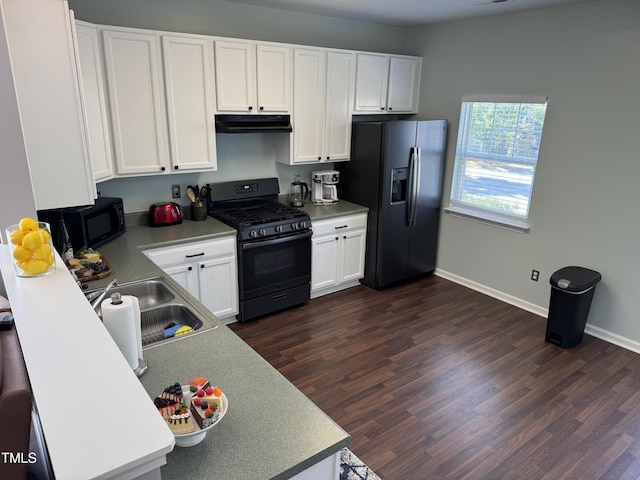 kitchen with a sink, range hood, black appliances, and dark wood-style flooring