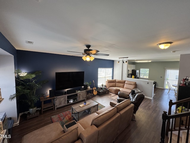 living area with visible vents, baseboards, ceiling fan, and wood finished floors