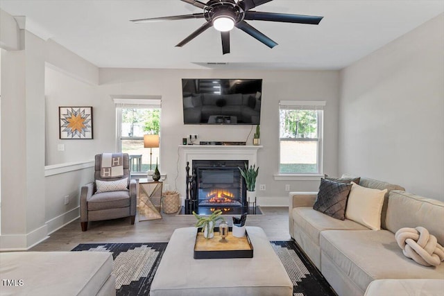 7729 Calcutta Dr, Willow Springs, NC 27592 - living area featuring ceiling fan, a glass covered fireplace, a healthy amount of sunlight, and wood finished floors