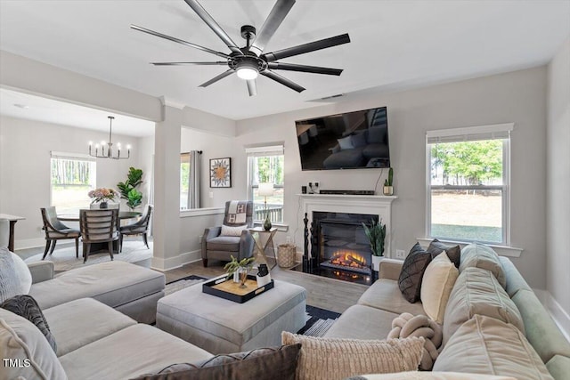 7729 Calcutta Dr, Willow Springs, NC 27592 - living area featuring baseboards, a glass covered fireplace, ceiling fan with notable chandelier, and a healthy amount of sunlight
