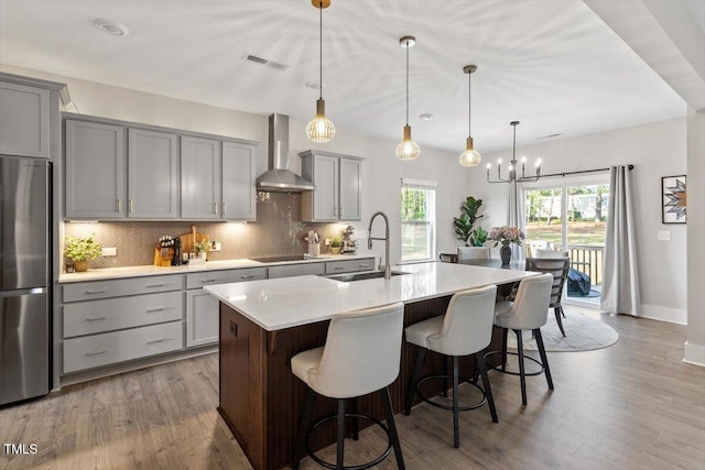 7729 Calcutta Dr, Willow Springs, NC 27592 - kitchen with freestanding refrigerator, black electric cooktop, gray cabinets, and wall chimney exhaust hood