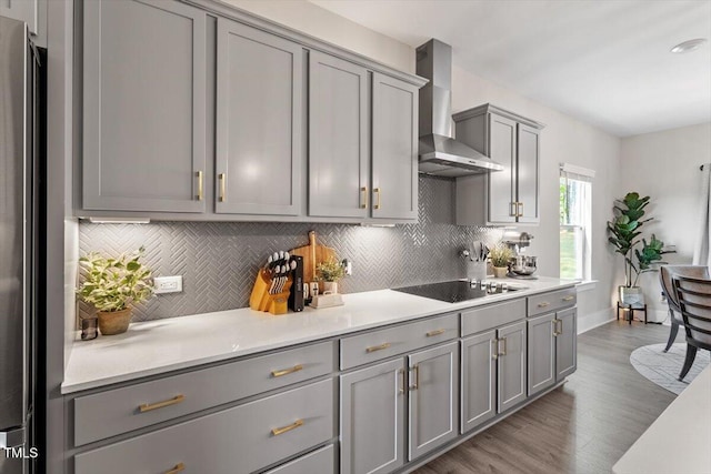 7729 Calcutta Dr, Willow Springs, NC 27592 - kitchen featuring black electric stovetop, gray cabinets, wall chimney exhaust hood, and tasteful backsplash