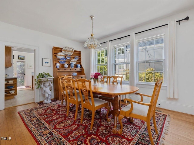 dining room featuring a notable chandelier and light wood-style flooring