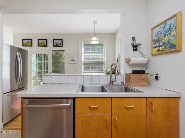 kitchen with light countertops, stainless steel appliances, a healthy amount of sunlight, and a sink