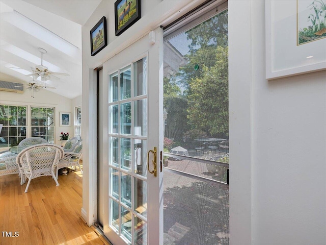 doorway featuring plenty of natural light, light wood finished floors, ceiling fan, and lofted ceiling