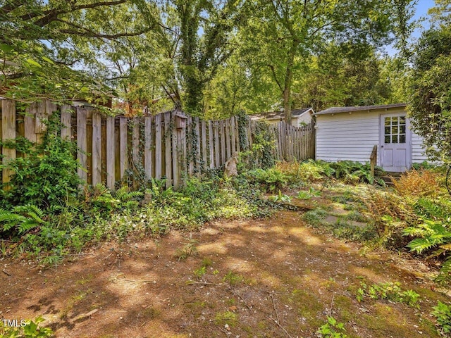 view of yard with fence and an outbuilding