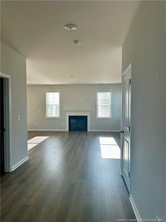 331 Brentmoor Dr, Raeford, NC 28376 - unfurnished living room featuring baseboards, dark wood finished floors, and a glass covered fireplace