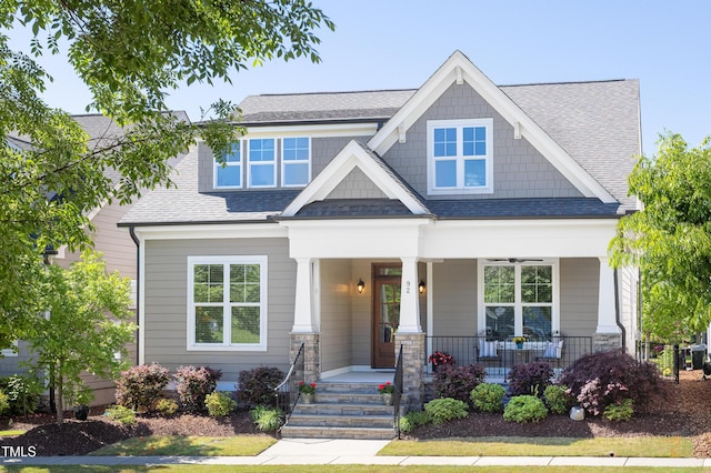 craftsman-style home with roof with shingles and covered porch