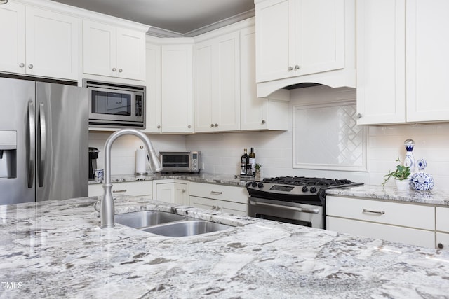 kitchen featuring a sink, appliances with stainless steel finishes, tasteful backsplash, and white cabinetry