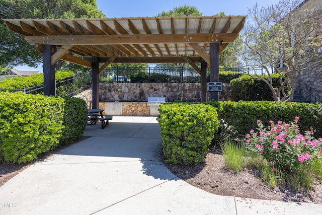 view of property's community with area for grilling, fence, and a patio area