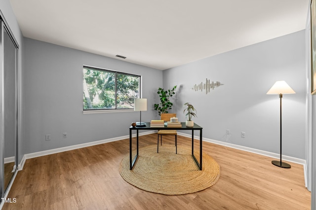 office space with visible vents, baseboards, and wood finished floors