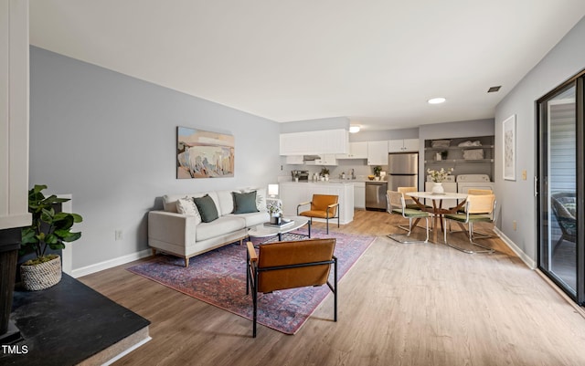 living room featuring baseboards and light wood-type flooring