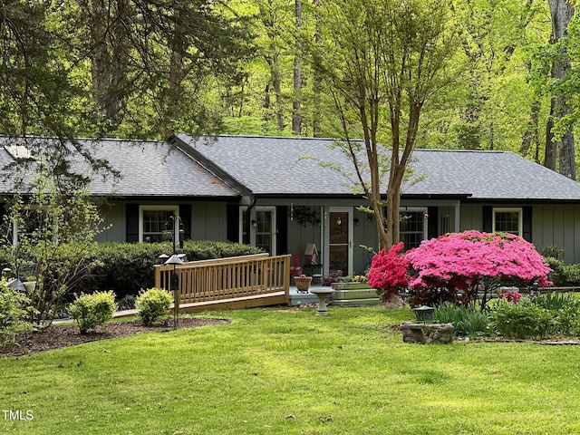 single story home featuring a shingled roof, covered porch, and a front lawn