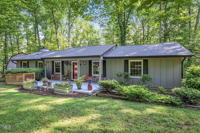 ranch-style house with a shingled roof and a front yard