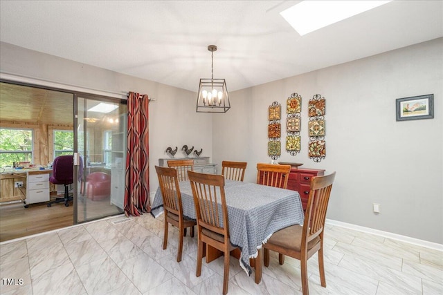 dining room with baseboards and a chandelier