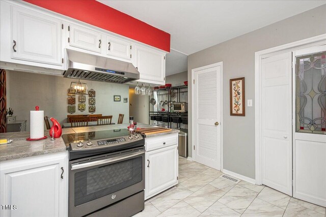kitchen with white cabinetry, electric stove, under cabinet range hood, light countertops, and marble finish floor