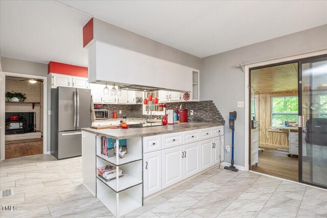 kitchen featuring freestanding refrigerator, open shelves, white cabinetry, backsplash, and marble finish floor