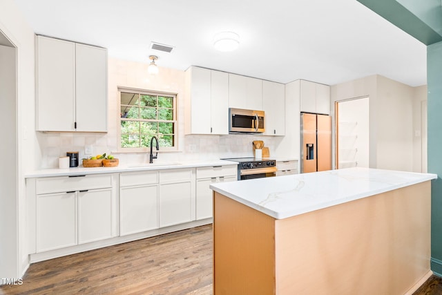 kitchen with electric range, a sink, light wood-style floors, stainless steel microwave, and refrigerator with ice dispenser