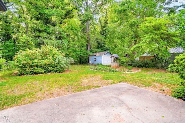 view of yard featuring a wooded view and an outdoor structure