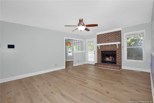 unfurnished living room featuring plenty of natural light, ceiling fan, and wood finished floors
