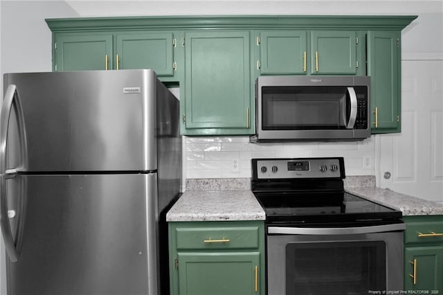 kitchen with appliances with stainless steel finishes, backsplash, and green cabinets