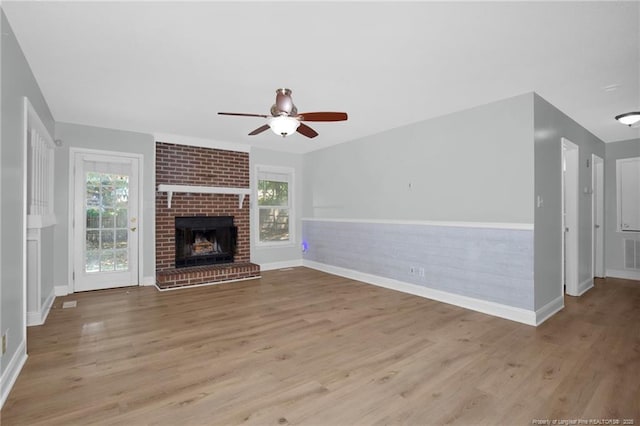 unfurnished living room featuring a ceiling fan, wood finished floors, and a wealth of natural light