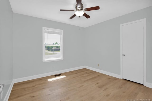 unfurnished room featuring baseboards, a ceiling fan, light wood-style flooring, and visible vents