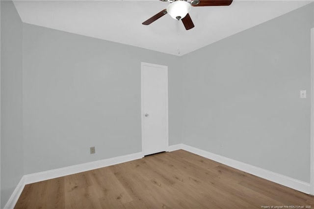 spare room featuring baseboards, ceiling fan, and wood finished floors