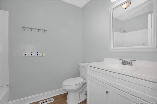 bathroom with visible vents, vanity, wood finished floors, toilet, and baseboards