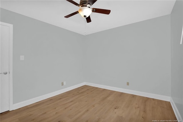 empty room featuring a ceiling fan, baseboards, and light wood-style floors