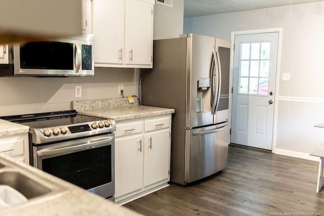 3254 Blossom Dr, Fayetteville, NC 28306 - kitchen with light countertops, dark wood-style flooring, white cabinets, and appliances with stainless steel finishes