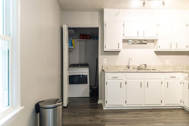 3254 Blossom Dr, Fayetteville, NC 28306 - kitchen with washer / clothes dryer, stove, a sink, white cabinetry, and dark wood-type flooring