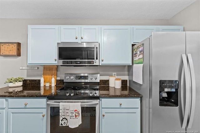 kitchen featuring dark stone counters, appliances with stainless steel finishes, and tile patterned flooring