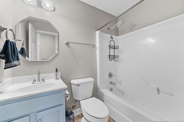 full bath featuring vanity, washtub / shower combination, baseboards, and toilet