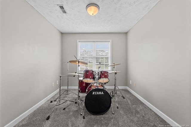rec room with baseboards, carpet flooring, a textured ceiling, and visible vents
