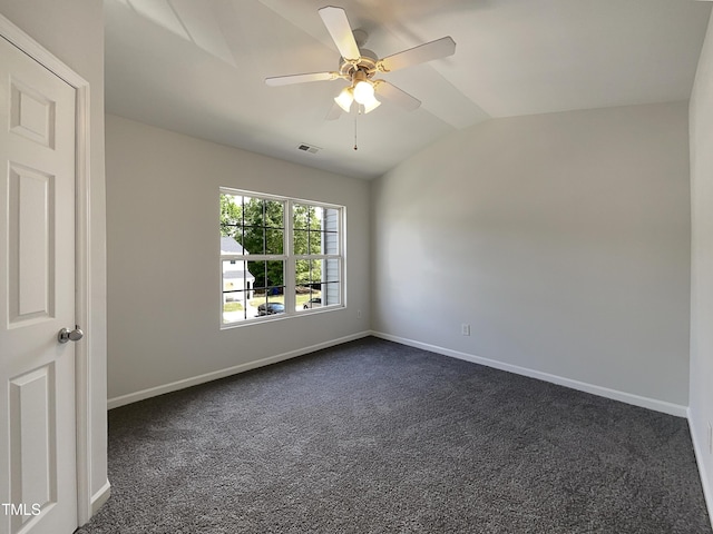 unfurnished room with ceiling fan, dark carpet, baseboards, vaulted ceiling, and visible vents