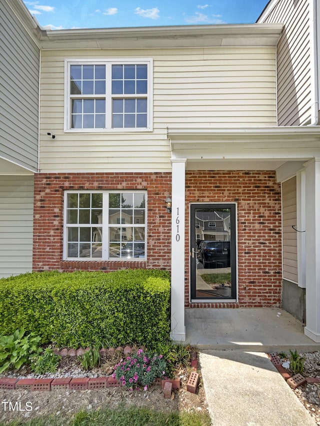 view of exterior entry with brick siding