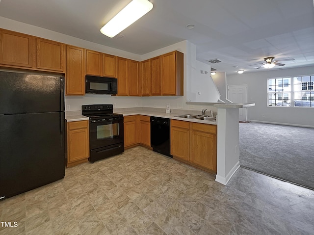 kitchen with a peninsula, light colored carpet, light countertops, a sink, and black appliances