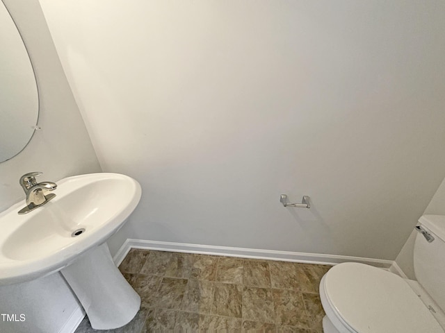 bathroom featuring baseboards and toilet