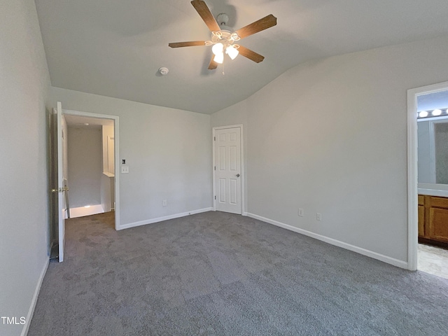 unfurnished bedroom featuring baseboards, carpet, and lofted ceiling