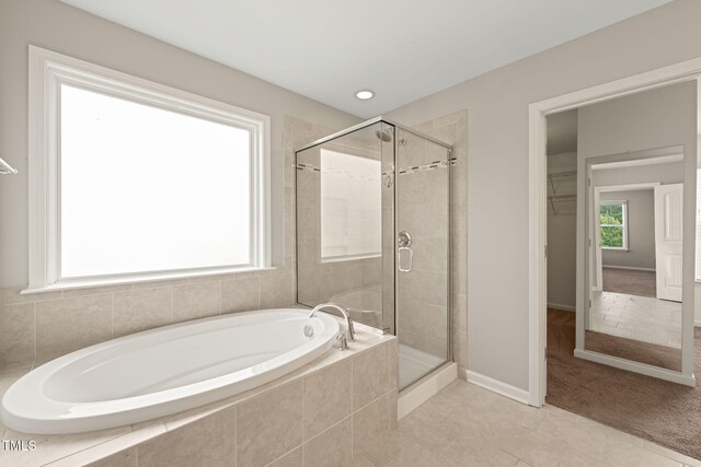 5011 Peachtree Town Ln, Knightdale, NC 27545 - bathroom featuring a bath, a shower stall, tile patterned flooring, and a walk in closet