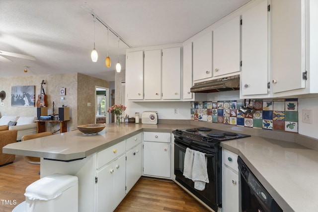 kitchen featuring under cabinet range hood, black appliances, a peninsula, light wood-style flooring, and a ceiling fan