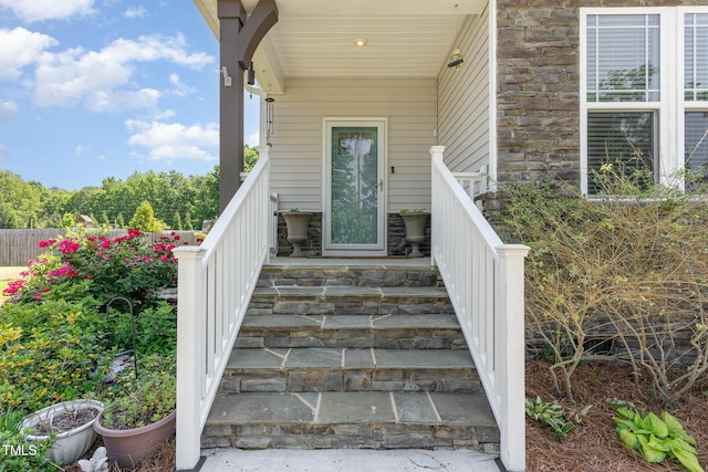 doorway to property featuring covered porch and stone siding