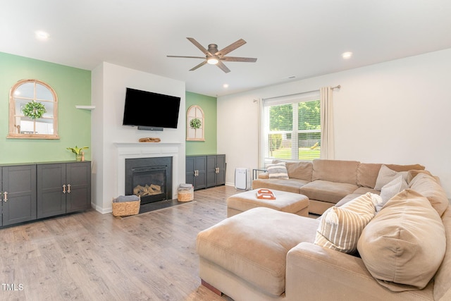 living room with light wood-style floors, a fireplace with flush hearth, ceiling fan, and recessed lighting