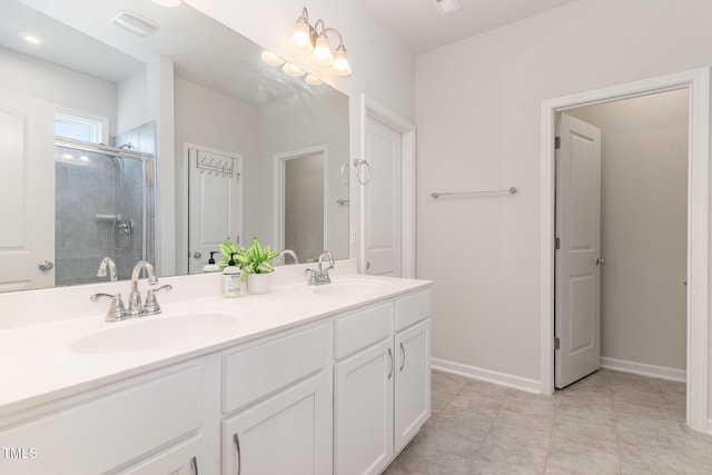 bathroom featuring a sink, baseboards, a tile shower, and double vanity