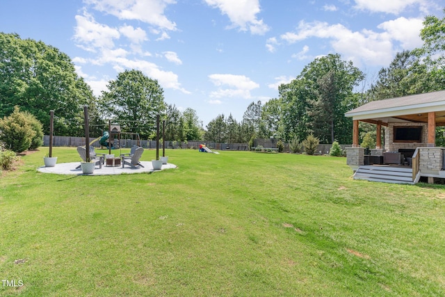 view of yard with a wooden deck, a fenced backyard, a playground, an outdoor hangout area, and a patio