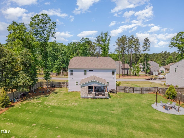 back of property with a lawn, a residential view, a patio area, a fenced backyard, and an outdoor fire pit