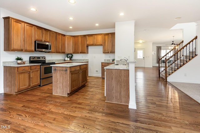 kitchen with stainless steel appliances, brown cabinets, dark wood-style flooring, baseboards, and recessed lighting