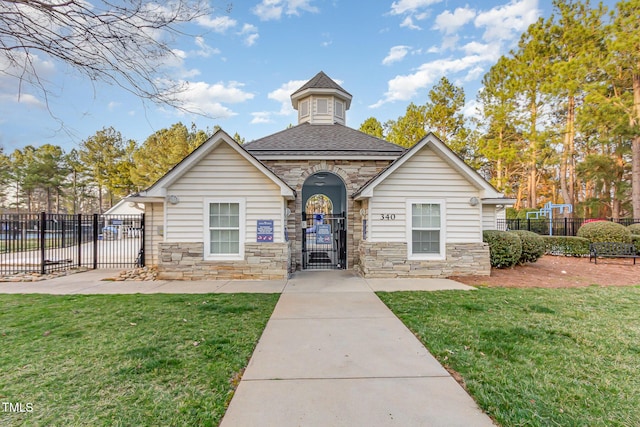 view of front of house featuring a gate, stone siding, and roof with shingles