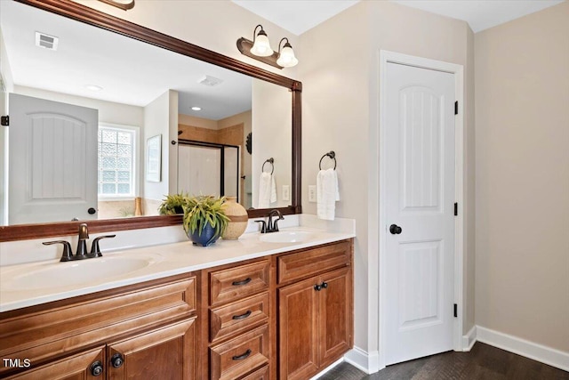 206 Wynngate Dr, Cameron, NC 28326 - bathroom with double vanity, a shower stall, wood finished floors, and baseboards